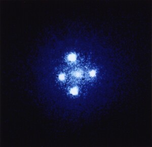 Left: 2M130-1714, in which the four bright and bluish points comprise the quadruply-lensed images of the bright nucleus of a background galaxy, such that the main body of the background galaxy is lensed and distorted into an Einstein ring. 